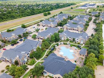 A bird's eye view of a residential area with houses and a swimming pool.